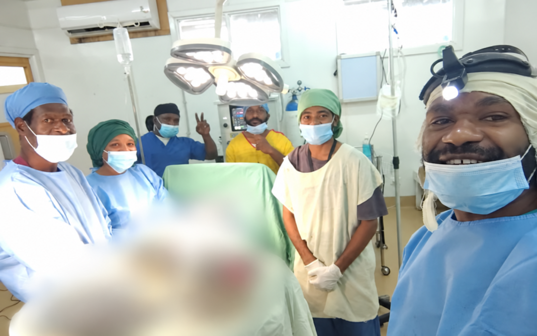 Students and hospital staff in theatre, with sensitive clinical areas digitally blurred.
