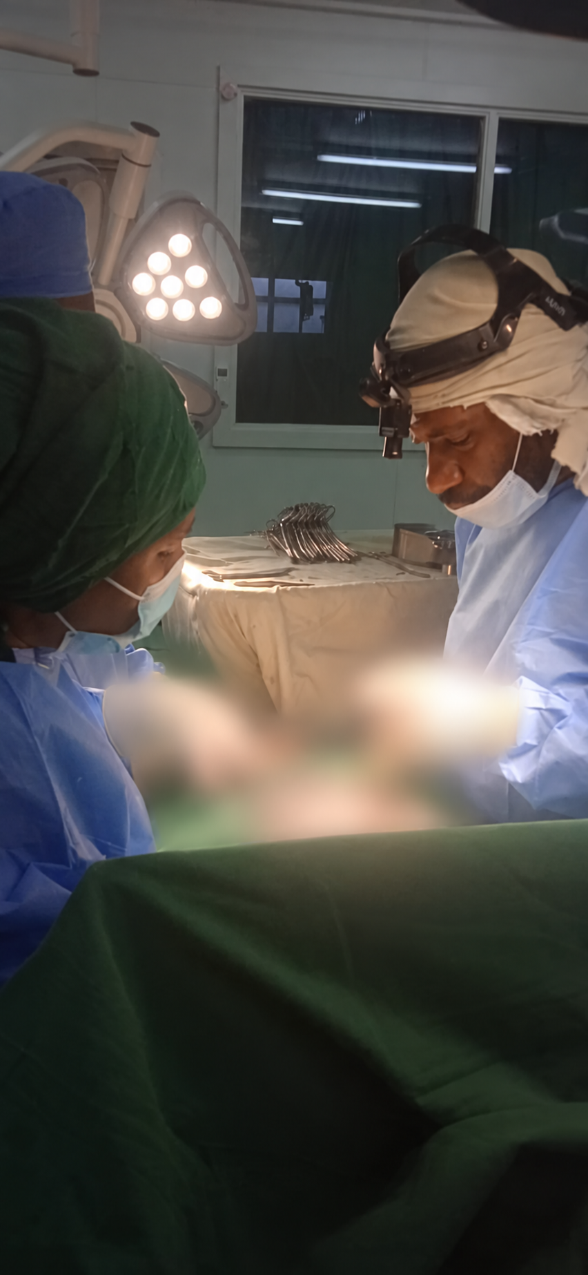 A supervised theatre scene at Daru Provincial Hospital, with sensitive clinical areas digitally blurred.